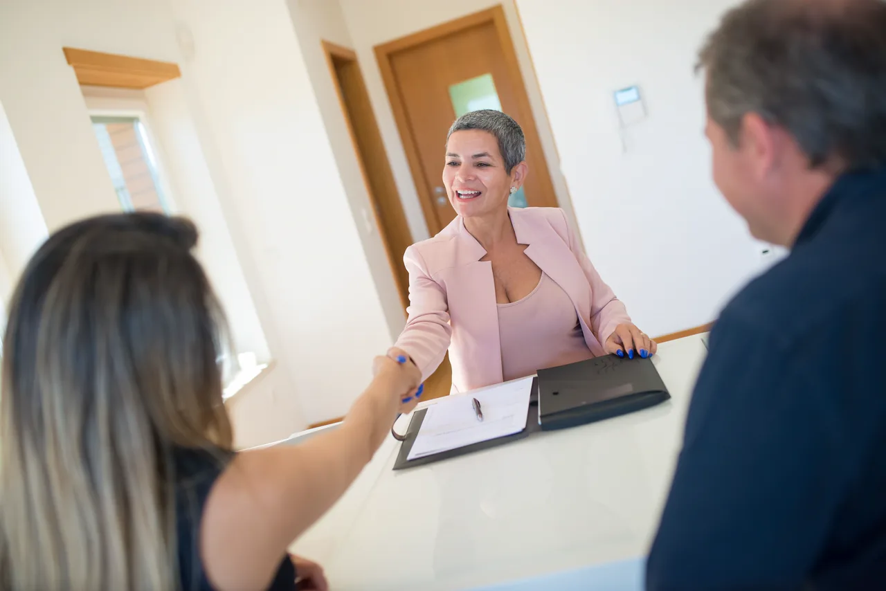 An attorney smiling across the table at two clients